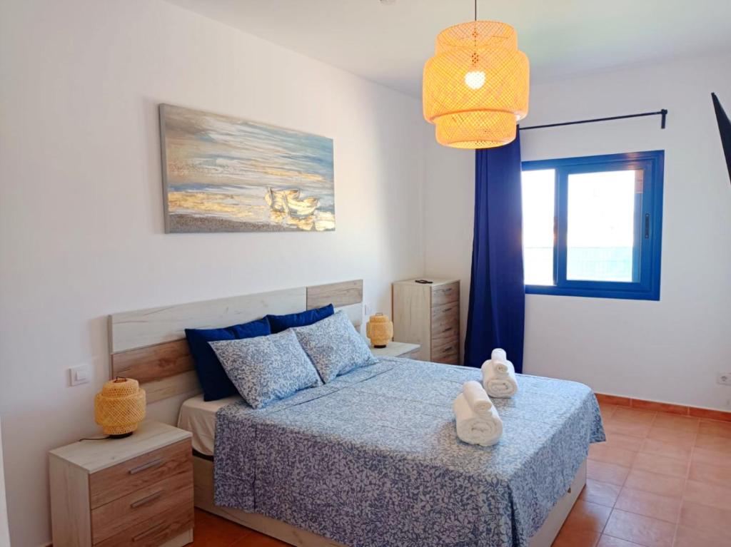 una camera con letto e luce a ciondolo di Casa Sol y Mar a Costa Calma