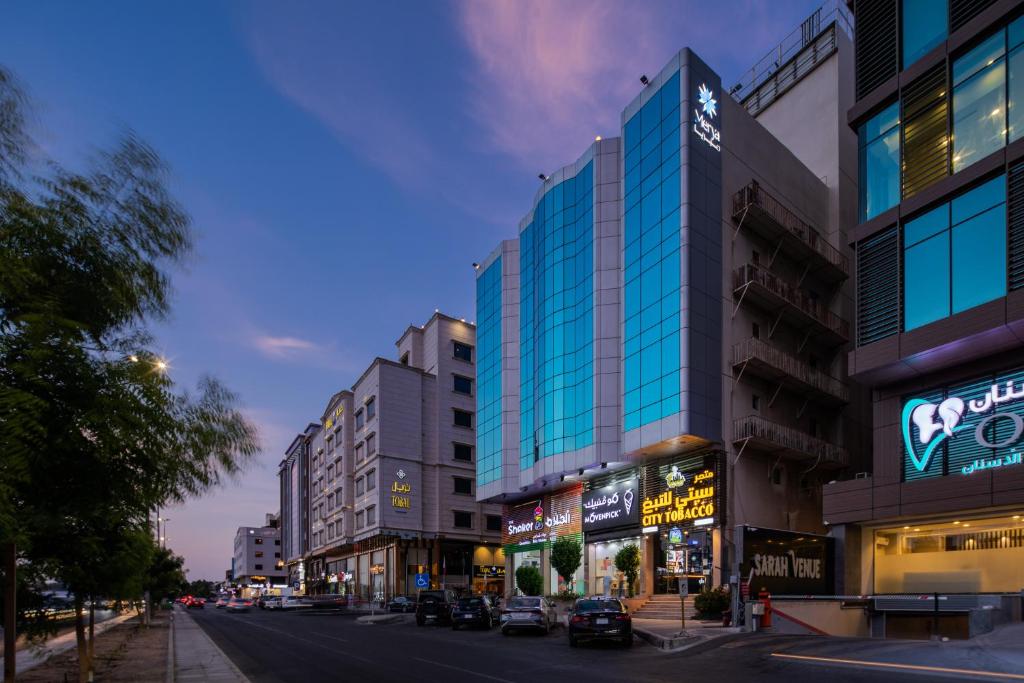 una calle de la ciudad con edificios altos y una calle en Merya Hotel - Zahra, en Yeda