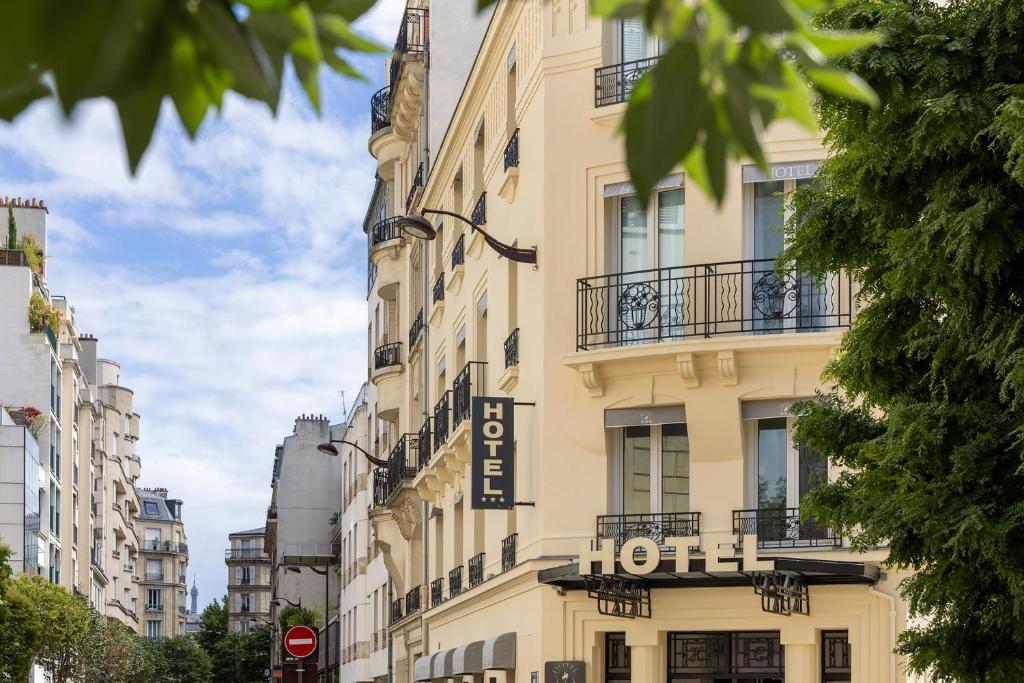 a building with a hotel sign on the side of it at Hotel Charlemagne in Neuilly-sur-Seine