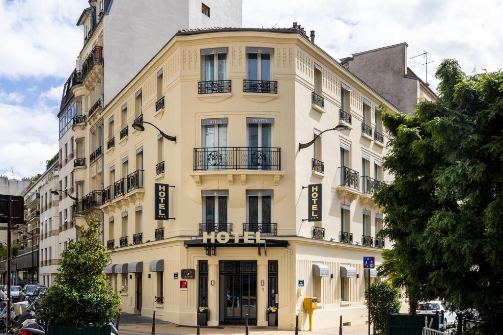 un gran edificio amarillo en una calle de la ciudad en Hotel Charlemagne, en Neuilly-sur-Seine
