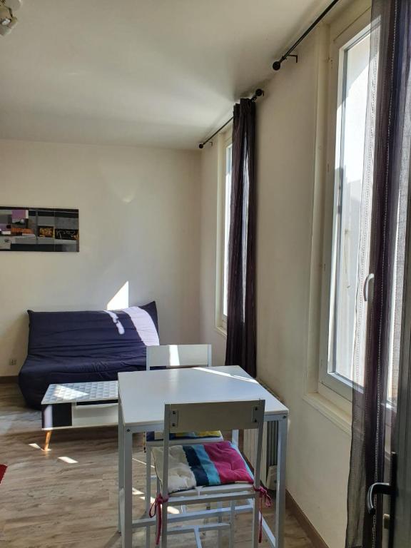 Zimmer mit einem Tisch, einem Bett und einem Fenster in der Unterkunft Appartement centre de rochefort in Rochefort