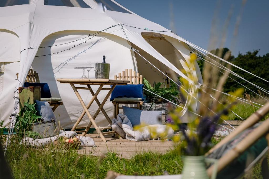 a tent with a table and chairs in the grass at Finchingfield Lavender in Finchingfield