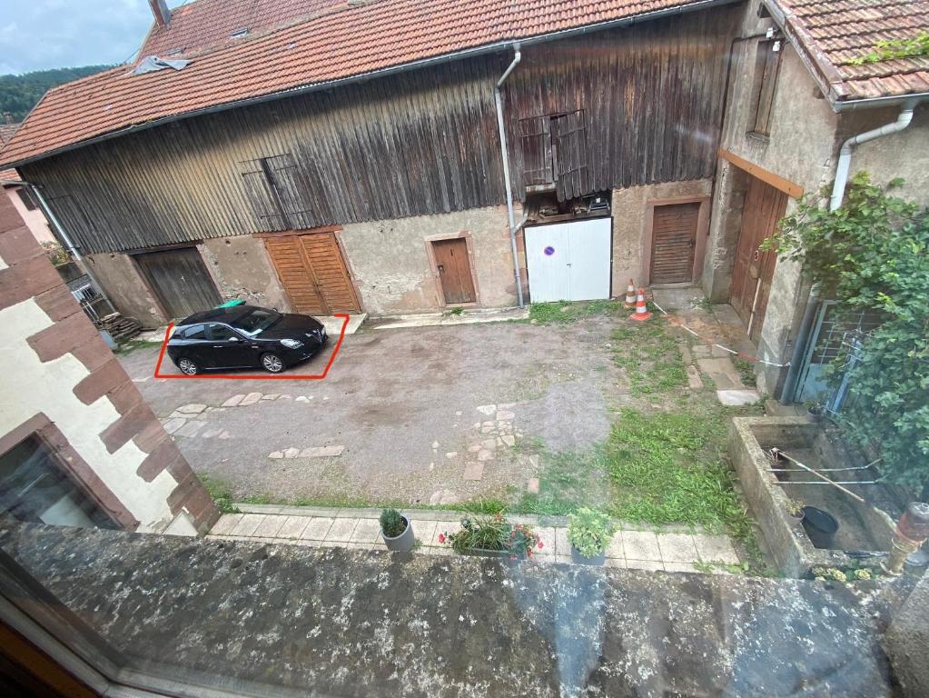 a car parked in a yard next to a building at Gîte chez Lulu proche du château de schirmeck in Schirmeck