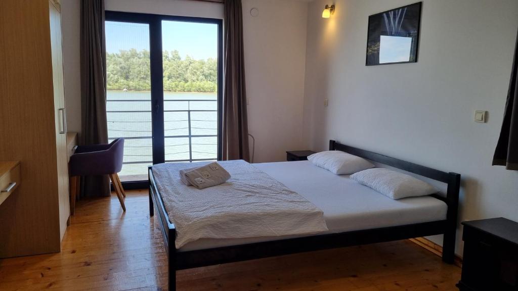 a bedroom with a bed and a large window at B&B Botel Charlie in Belgrade