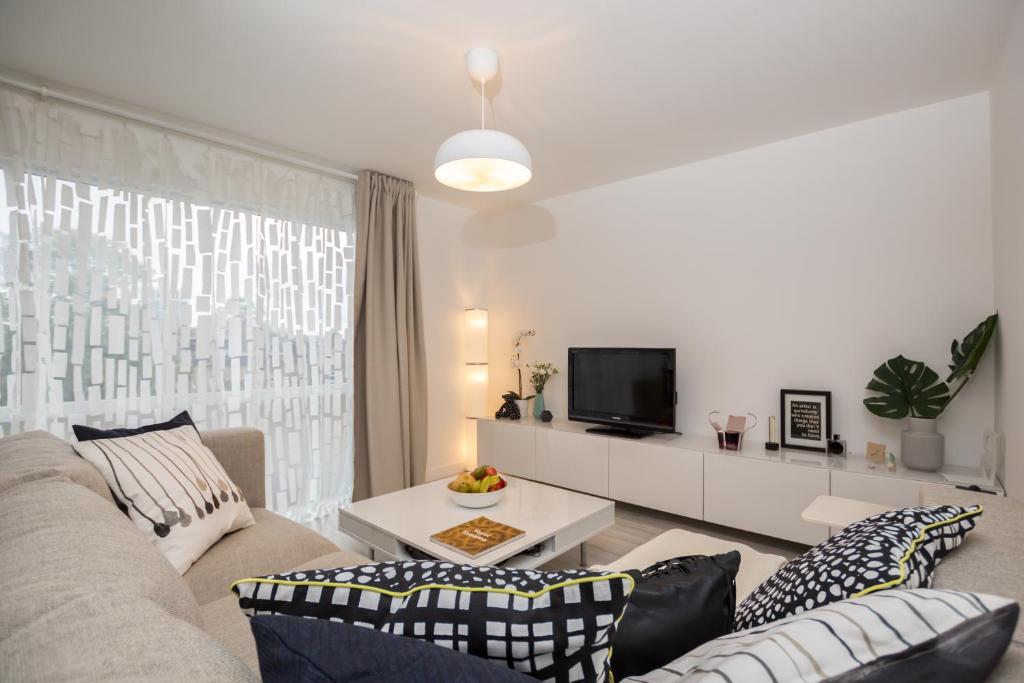 a living room with a couch and a tv at Stylish and Cosy 1 BDR Apt, Ealing Broadway in London