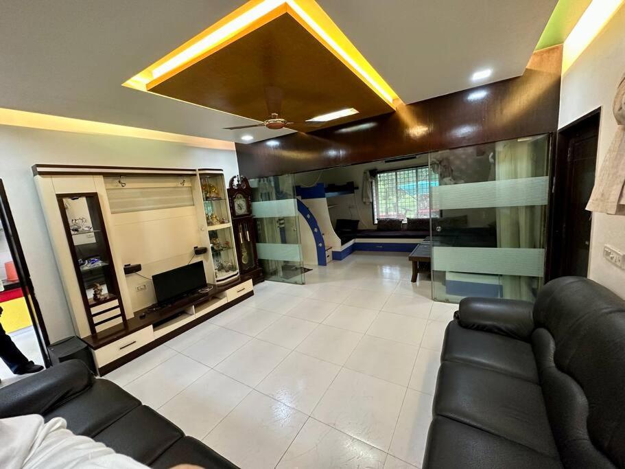 een woonkamer met een bank en een tv bij Farm stay in Ahmedabad in Ahmedabad
