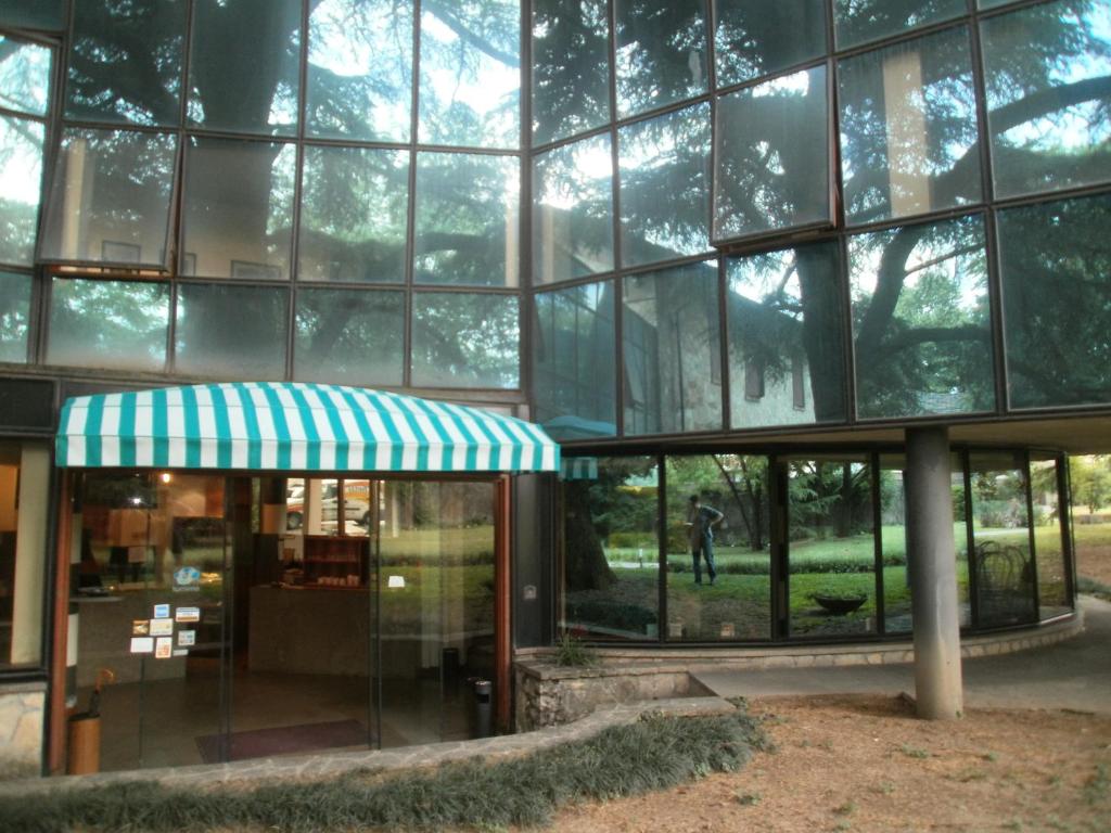 a large glass building with a tree in front of it at Albergo Villa & Roma in Palazzolo sullʼOglio