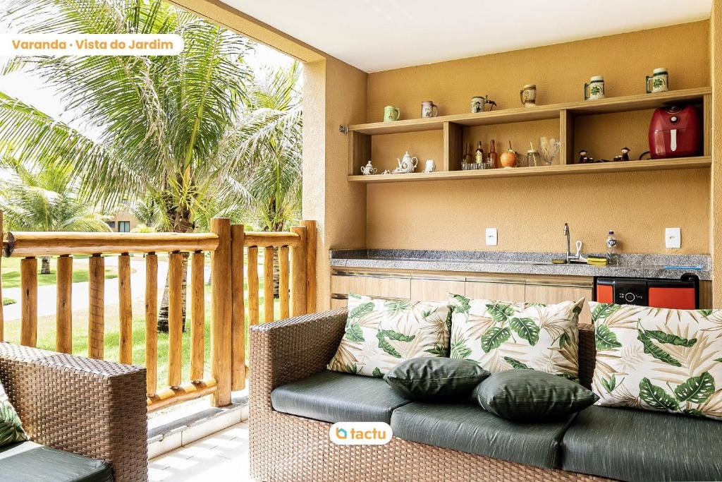 a living room with a couch and a balcony at Térreo completo e gigante VG Sun Cumbuco por Tactu in Cumbuco