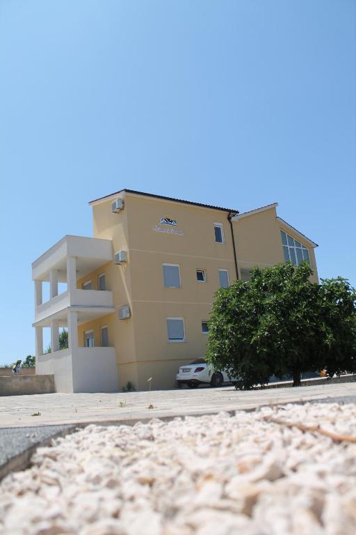 a yellow building with a car parked in front of it at Villa Branko in Vodice