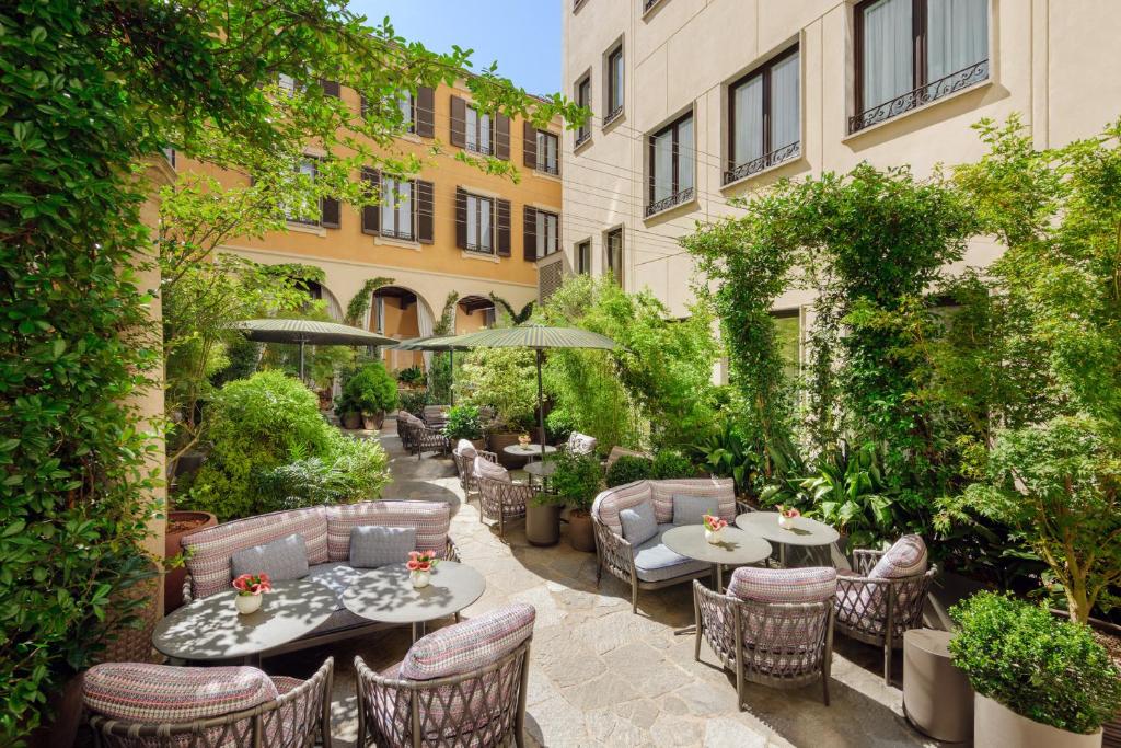 a patio with tables and chairs in a courtyard at Mandarin Oriental, Milan in Milan
