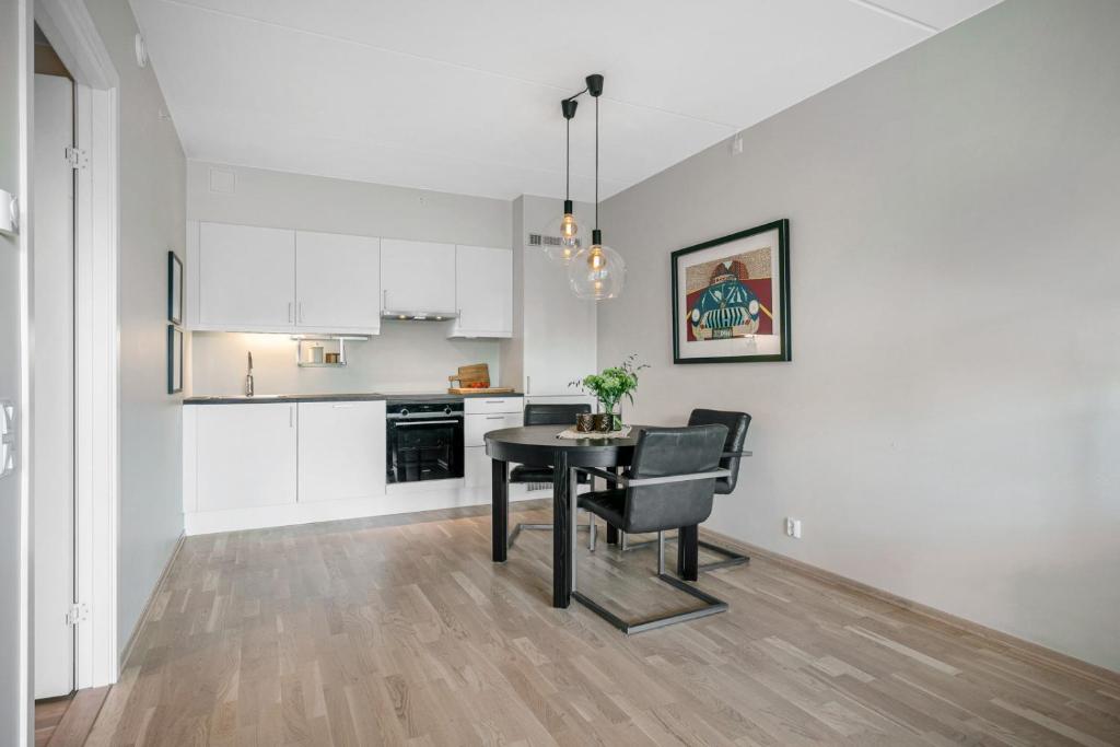 a kitchen with a table and chairs in a room at Rose in Sandvika