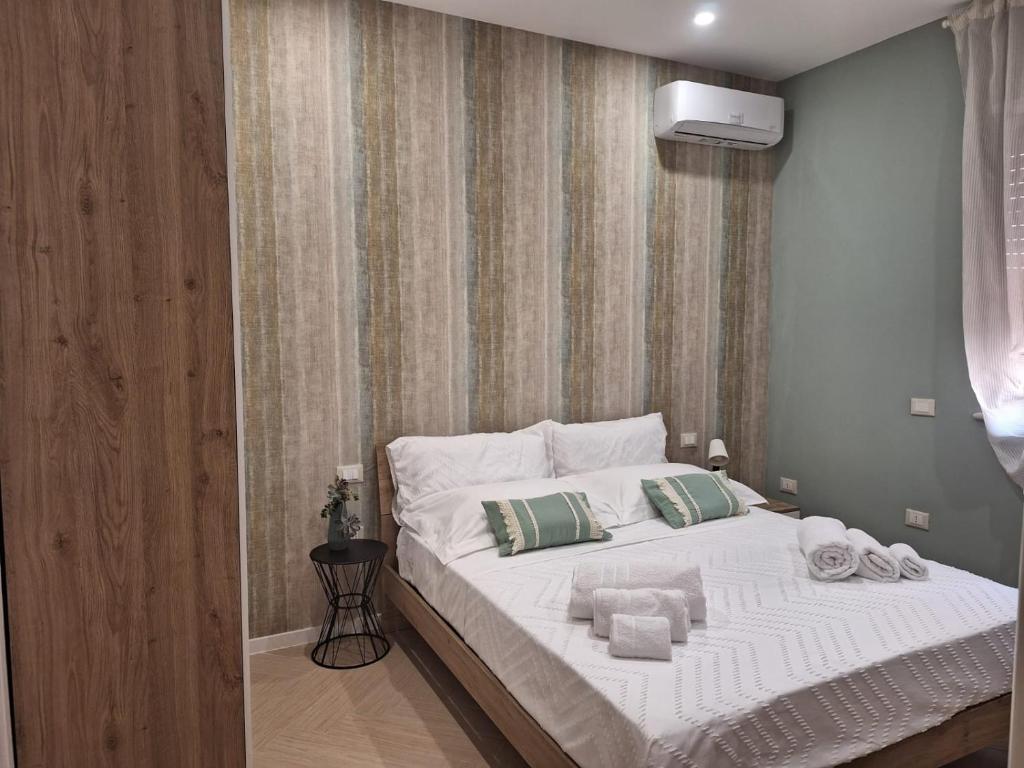 una camera da letto con un grande letto con asciugamani di DOMUS 0143 a San Giorgio Ionico