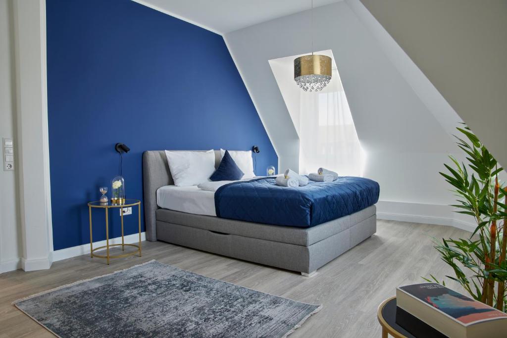 ein Schlafzimmer mit einer Wand mit blauen Akzenten und einem Bett in der Unterkunft Schlossberg Residences - XXL-Design-Apartment mit Schlossblick für bis zu 10 Personen in Schwetzingen