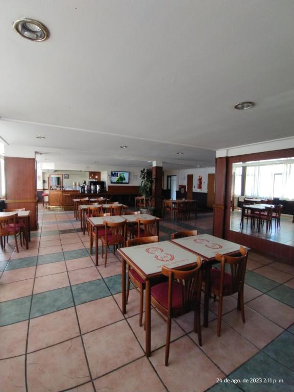 uma sala de jantar com mesas e cadeiras num restaurante em Hotel Victoria em Comodoro Rivadavia