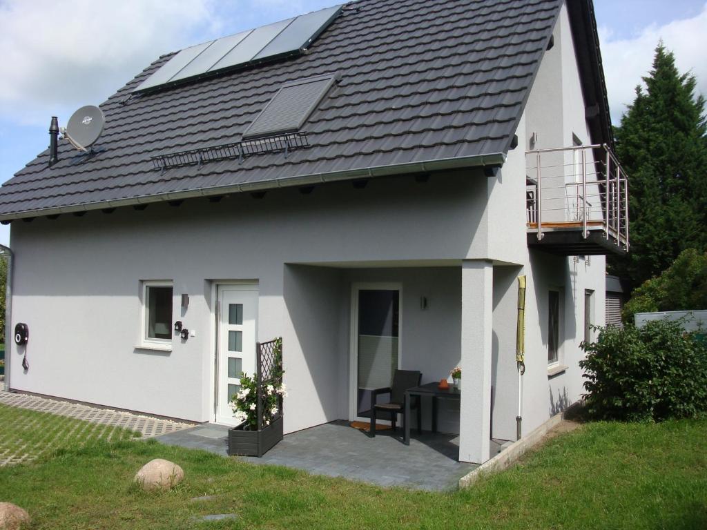 a white house with solar panels on the roof at Ferienwohnung Stübgen in Burg