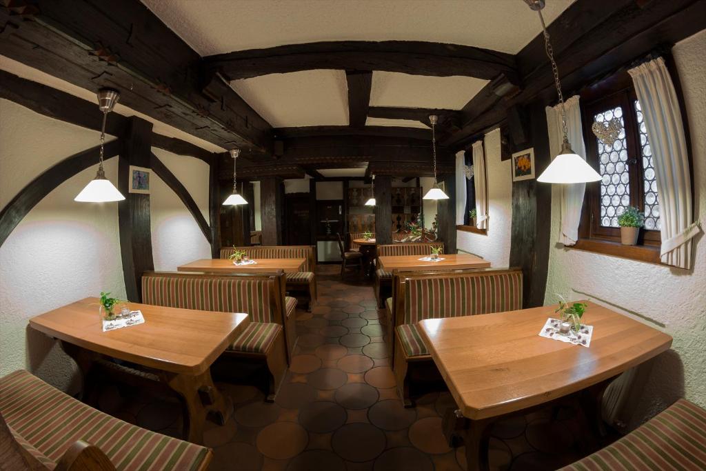 a restaurant with wooden tables and chairs in a room at Ratskeller Niederurff - Hotel &amp; Restaurant in Bad Zwesten