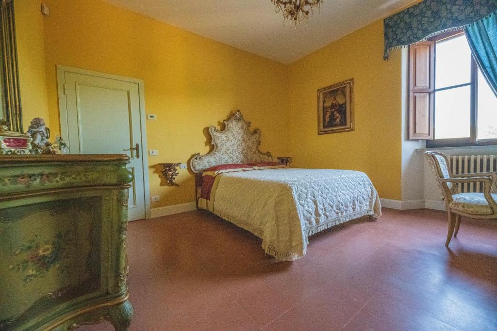 1 dormitorio con 1 cama en una habitación con paredes amarillas en Suite con Bagno in villa esclusiva - Urbino, en Urbino