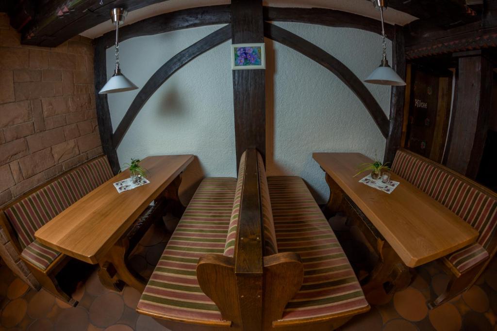 two tables and benches in a restaurant with lights at Ratskeller Niederurff - Hotel &amp; Restaurant in Bad Zwesten