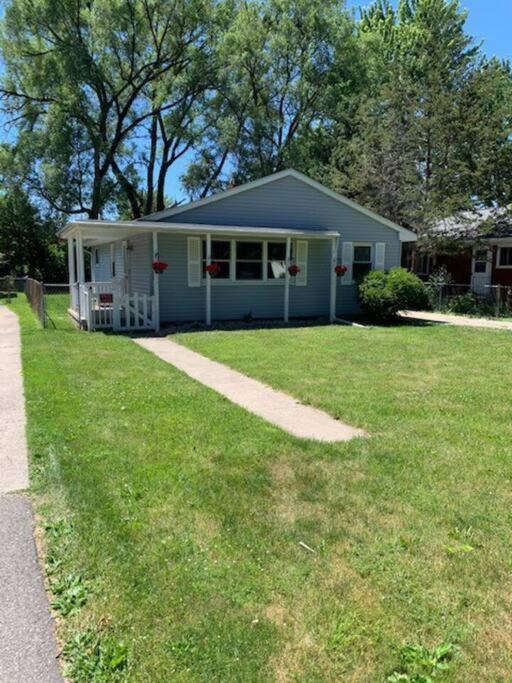 uma casa com um relvado verde em frente em Quiet home three bedroom home in peaceful neighborhood em Saginaw