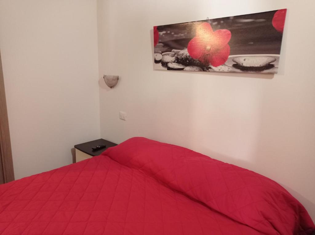 a bedroom with a red bed with a picture on the wall at AFFITTACAMERE RISTORANTE GUAITA SANT'EUTIZIO in Preci