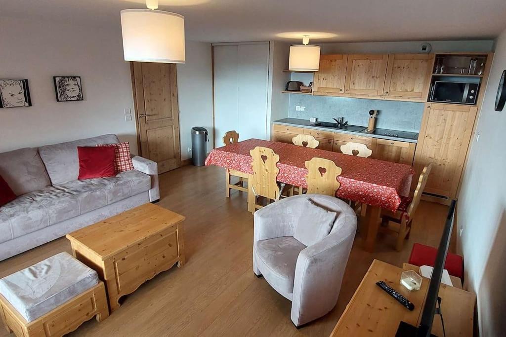 a living room with a table and a couch at Paradiski bel appartement rénové plan peisey in Peisey-Nancroix
