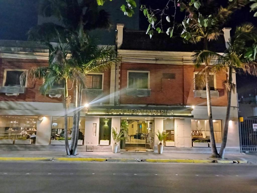 a building with palm trees in front of it at Hotel Hernandarias in Santa Fe