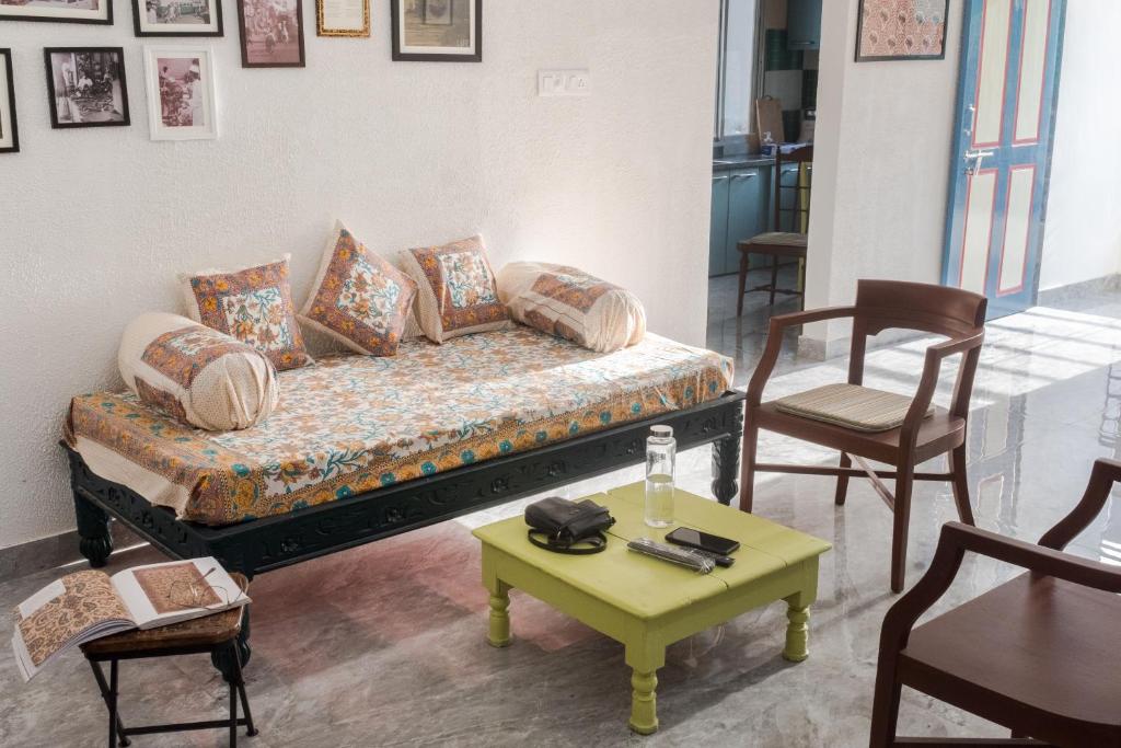 a room with a bed and a table and chairs at Ashray - Vintage Homes in Hyderabad