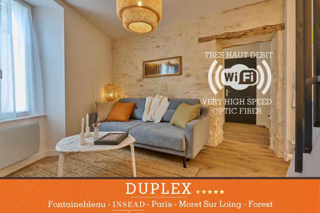 uma sala de estar com um sofá e uma mesa em Appartement standing à 7min de Fontainebleau centre, 3min de Moret-sur-Loing et 45min de Paris (1min à pied de la gare) em Veneux-les-Sablons