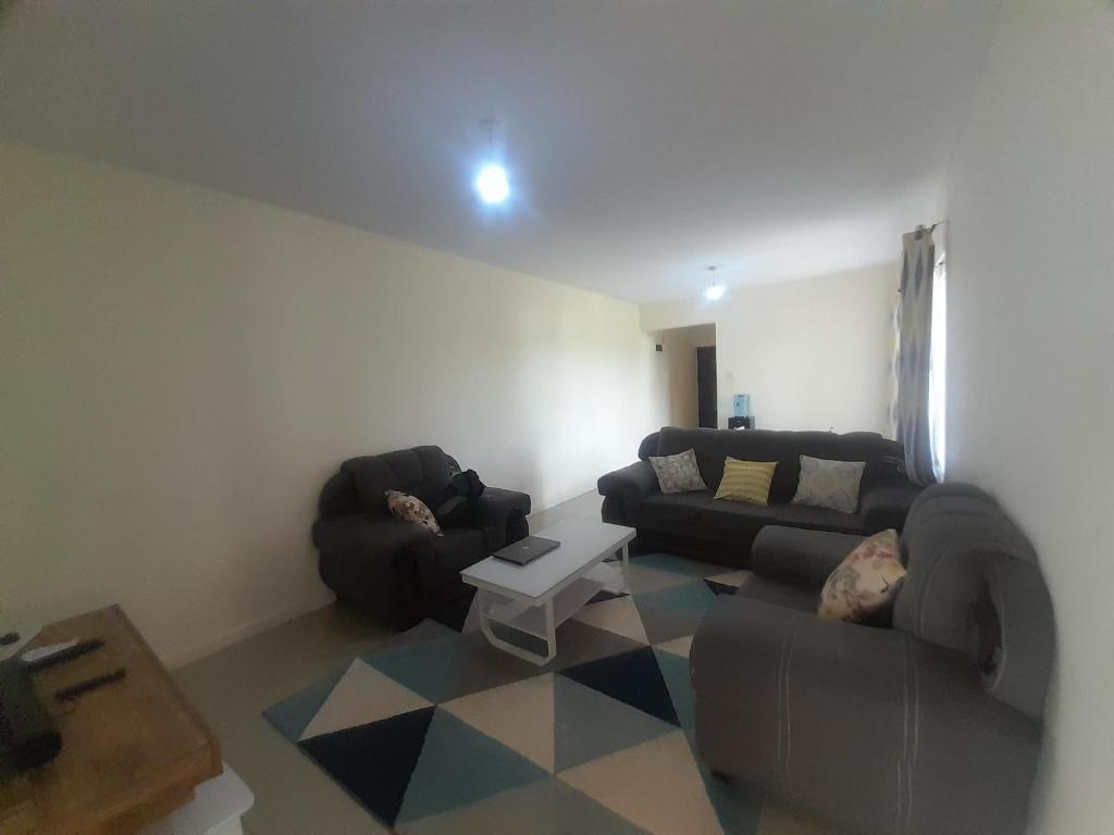 Sala de estar con 2 sofás y mesa en seville suites en Eldoret