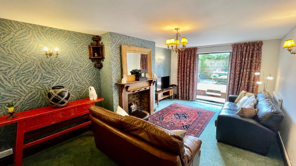 a living room with a couch and a fireplace at Beautiful Mumbles/Gower cottage in Swansea