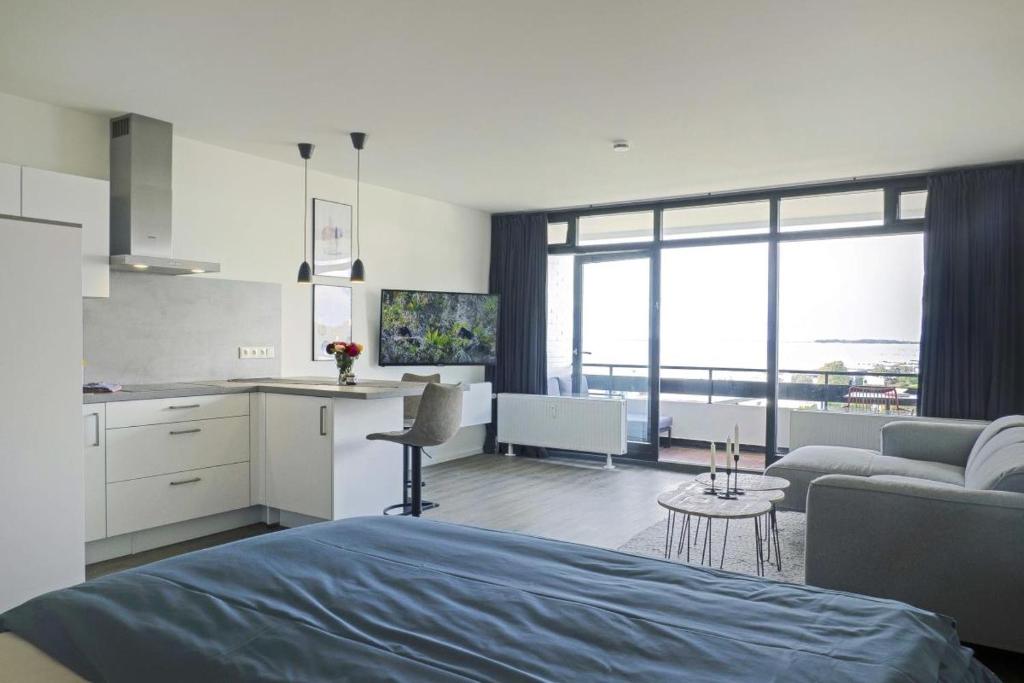 a bedroom with a kitchen and a living room at Traumhaftes Strand-Apartment mit Meerblick in Staberdorf