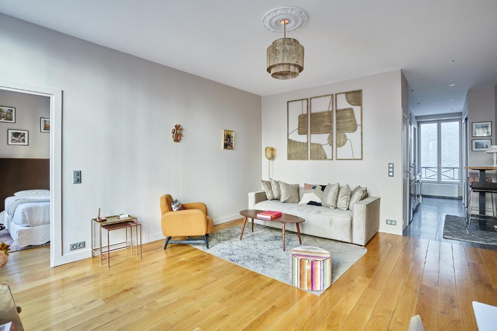 un salon avec un canapé et une table dans l'établissement Apartement Champs Elysée by Studio prestige, à Paris