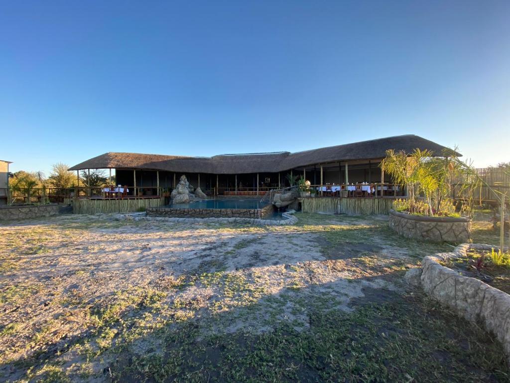 ein Resort mit einem großen Gebäude im Hintergrund in der Unterkunft Mababe River Lodge & Campsite in Mababe
