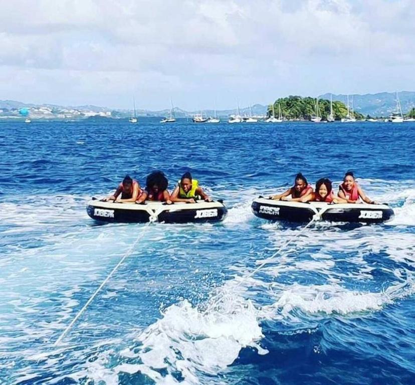 a group of people riding on an inflatable boat in the water at Apt T1,bien situé Anse Mitan Trois Ilets in Les Trois-Îlets
