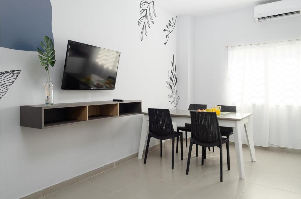 ein Esszimmer mit einem Tisch und einem TV an der Wand in der Unterkunft LA MEJOR ESTADIA EN SANTIAGO DEL ESTERO in Santiago del Estero
