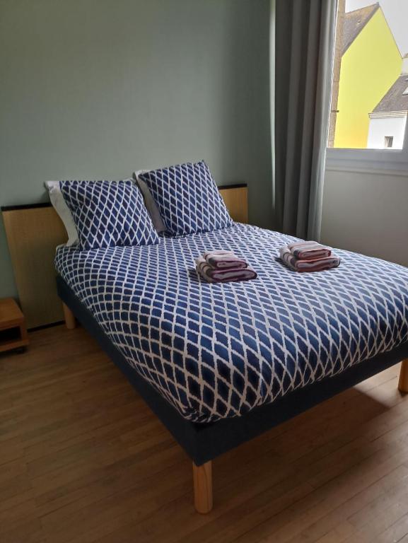 a bed with two towels on top of it at Appartement de charme - Lorient in Lorient