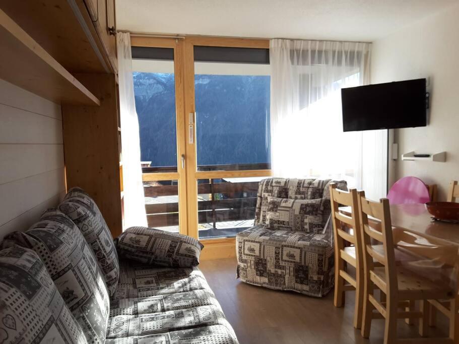 un salon avec un canapé, des chaises et une table dans l'établissement Paradiski proche des pistes plan peisey, à Peisey-Nancroix