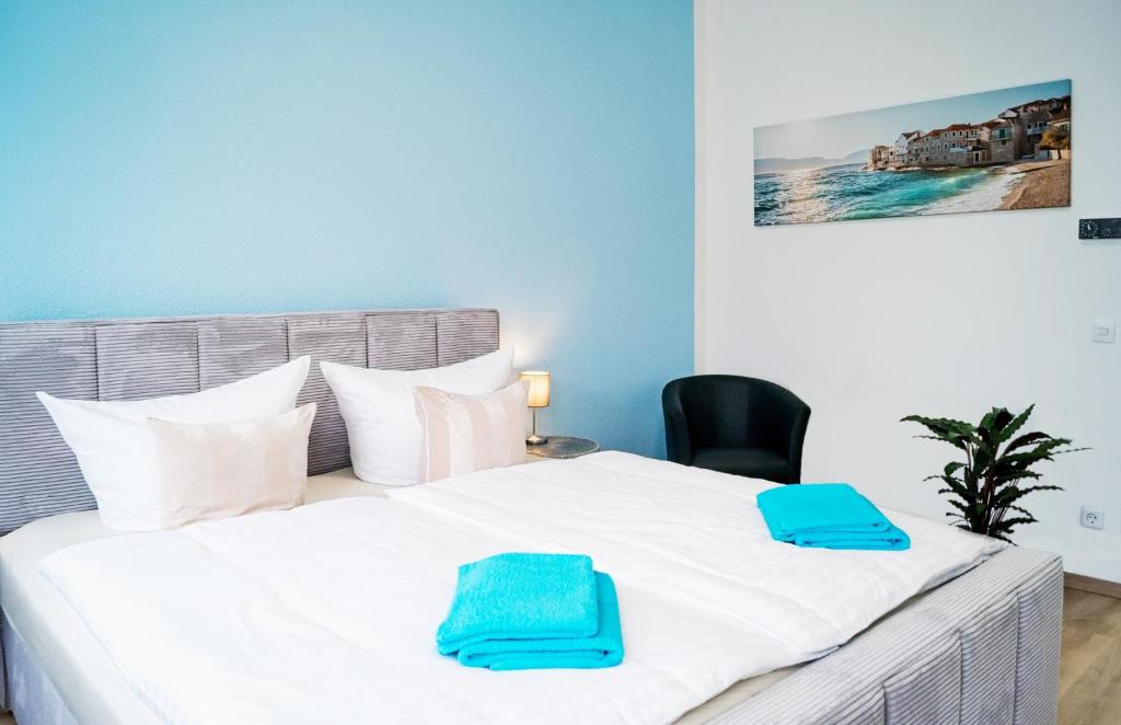 ein Schlafzimmer mit einem Bett mit zwei blauen Handtüchern darauf in der Unterkunft Die ideale Wohnung in Solingen
