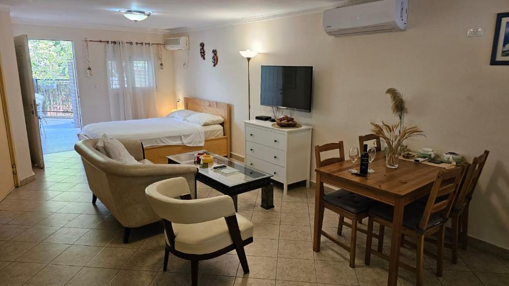 een woonkamer met een kamer met een bed en een tafel bij Kfar Vradim Hosting in Kefar Weradim