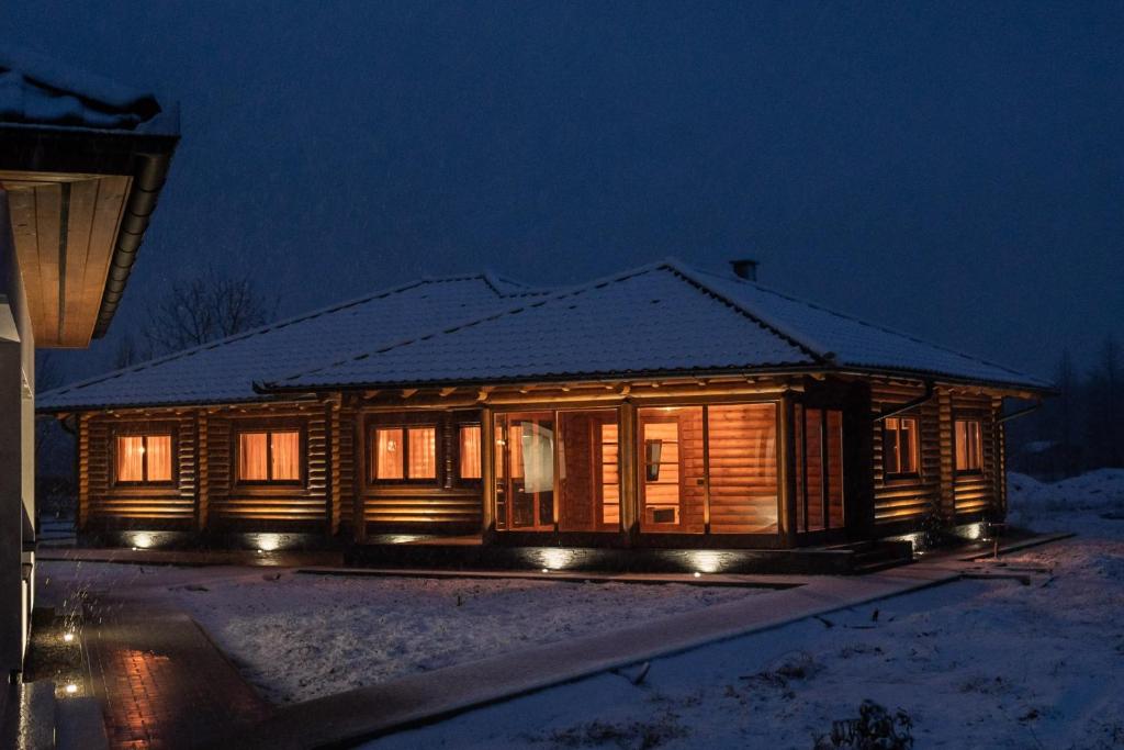 a wooden cabin in the snow at night at Mítosz Apartman in Gyomaendrőd