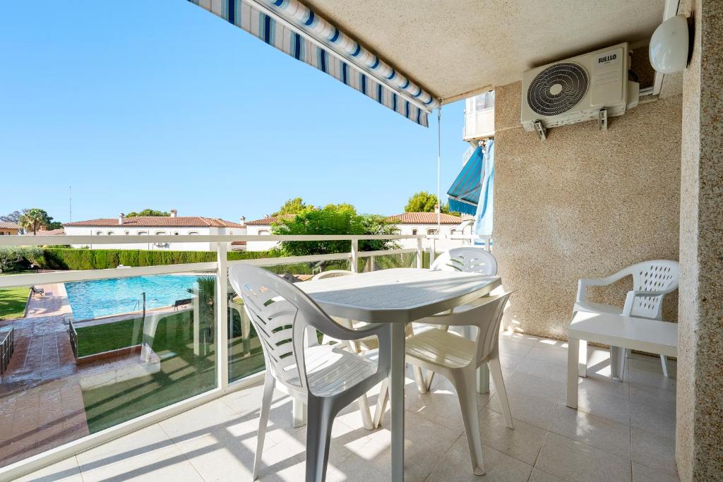 a dining room with a table and chairs and a balcony at Residencial Los Pelicanos in Hospitalet de l'Infant