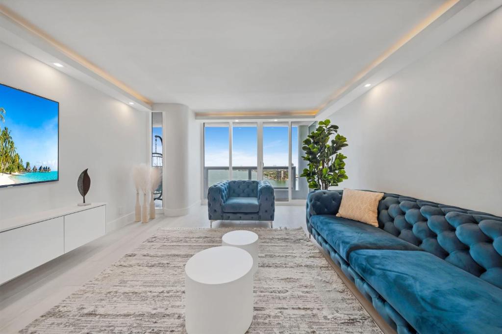 a living room with a blue couch and a tv at Blooming Sun Direct Ocean View in Miami