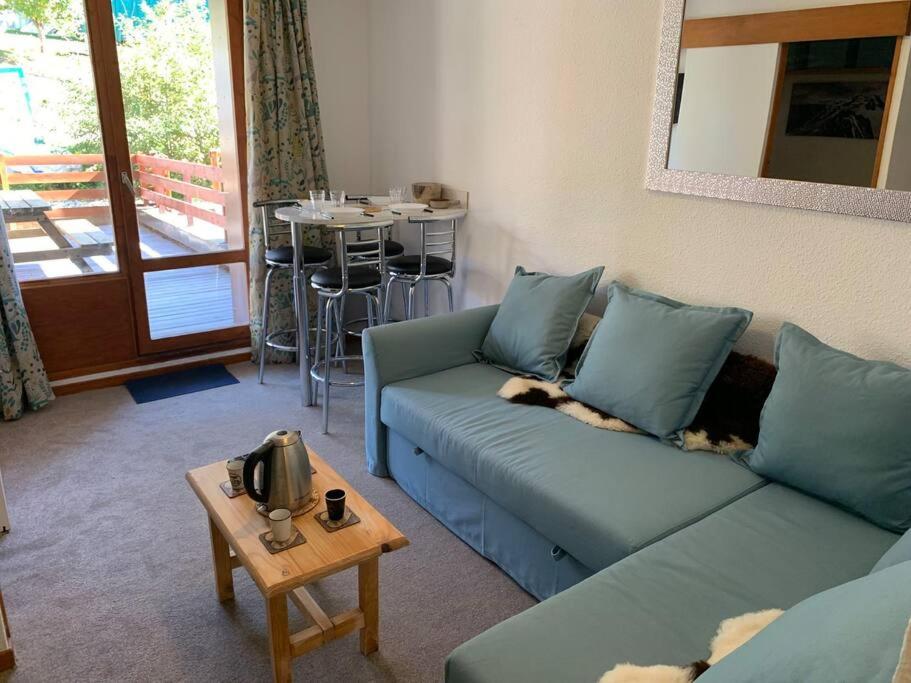een woonkamer met twee blauwe banken en een tafel bij Paradiski ski au pied vallandry in Landry