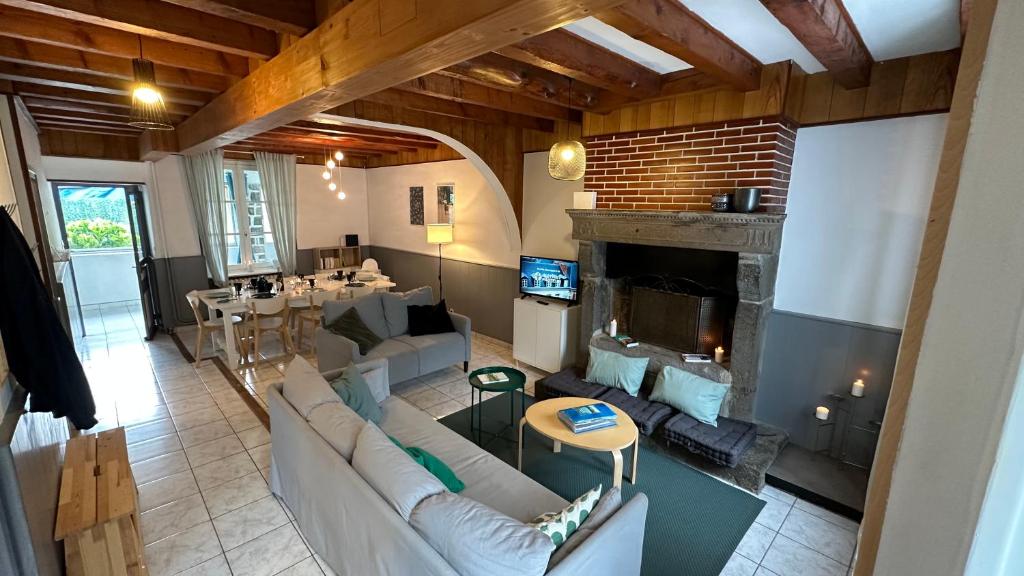 een woonkamer met een bank en een open haard bij Villa Stella 8pers. La Bourboule in La Bourboule