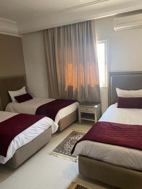 Cette chambre comprend 2 lits et une fenêtre. dans l'établissement Pacha hotel, à Sfax