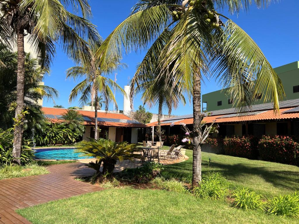 a resort with a swimming pool and palm trees at Premier Garden Hotel in José Bonifácio