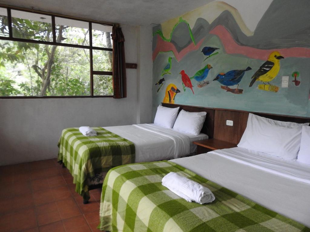 Postel nebo postele na pokoji v ubytování Biohostal Mindo Cloud Forest