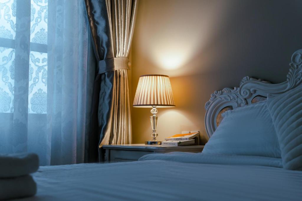 um quarto com uma cama com um candeeiro e uma janela em Louisa The Gold View Apartment em Ho Chi Minh