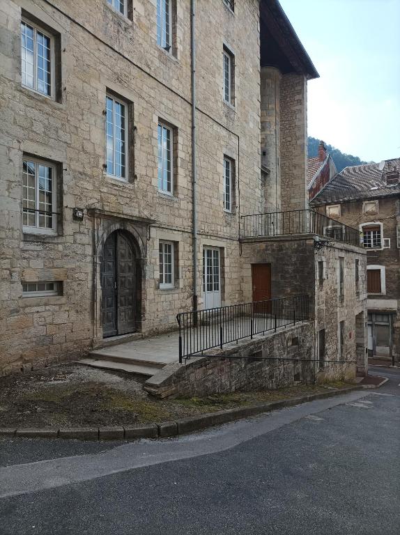 - un grand bâtiment en briques avec une porte et un escalier dans l'établissement O'Couvent - Appartement 71 m2 - 1 chambre - A222, à Salins-les-Bains