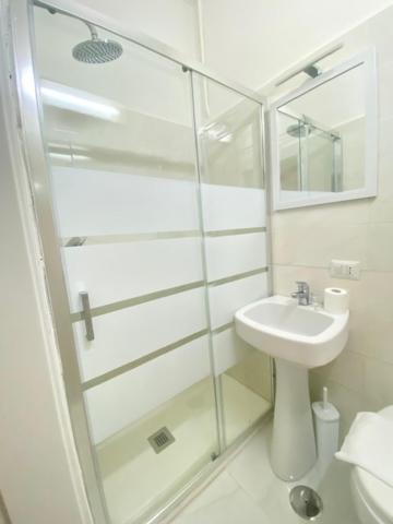 a bathroom with a glass shower and a sink at Hotel Resi in Rome